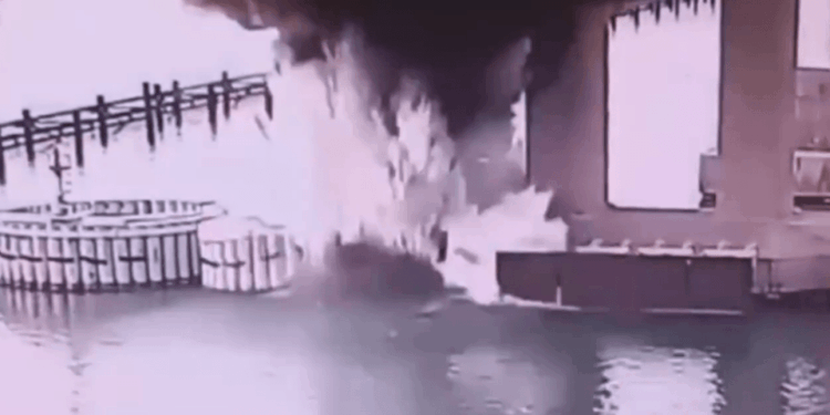 Gran fuego y humo cerca de un cuerpo de agua.