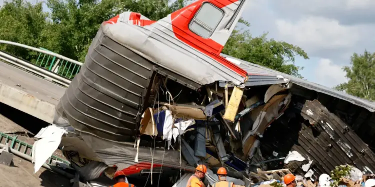 Los especialistas en servicios de emergencia se reúnen cerca de un carruaje destruido en la escena, después de que un puente de carretera se derrumbó en vías del ferrocarril que descarrilaba un tren que se acercaba en la región de Bryansk, Rusia, el 1 de junio de 2025. (Stringer/Reuters)