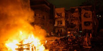 Bomberos y personal de rescate en el sitio de un incendio después de un ataque de misiles.