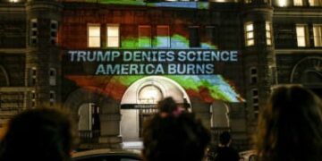 Los activistas proyectan llamas y comentarios sobre el lado del Hotel Internacional de Trump en protesta por la respuesta del presidente Donald Trump a la ciencia y el cambio climático frente a los devastadores incendios forestales en todo Estados Unidos el 21 de octubre de 2020, en Washington, DC.