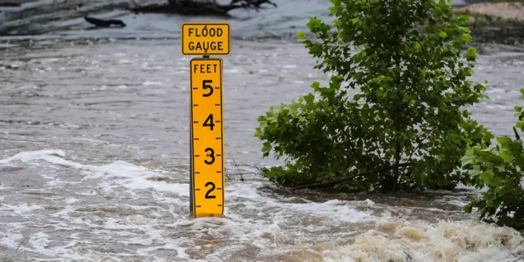 Un medidor de inundación marca la altura del agua que fluye sobre una carretera de la granja al mercado cerca de Kerrville, Texas, el 4 de julio de 2025. (Foto de Eric Gay/AP)