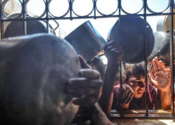 Los palestinos se alinean para la distribución de alimentos de caridad en la ciudad de Gaza