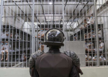 Un oficial de la prisión protege una celda en Cecot de la Penitenciaría de Máxima Seguridad (Centro para la Vivienda obligatoria del Terrorismo) el 4 de abril de 2025, en Tecoluca, San Vicente, El Salvador.