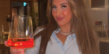 Bella Culley sosteniendo un vaso de Aperol Spritz.