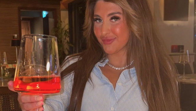 Bella Culley sosteniendo un vaso de Aperol Spritz.