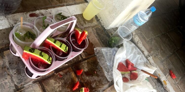 Cócteles preparados inseguamente con sandía y otros ingredientes en el suelo.