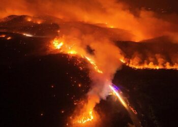 Vista aérea de un gran incendio forestal por la noche.