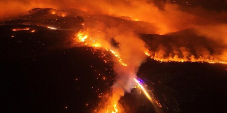 Vista aérea de un gran incendio forestal por la noche.