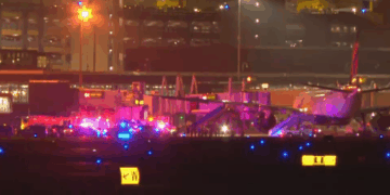 Vehículos de emergencia que rodean un avión en una pista de aeropuerto por la noche.