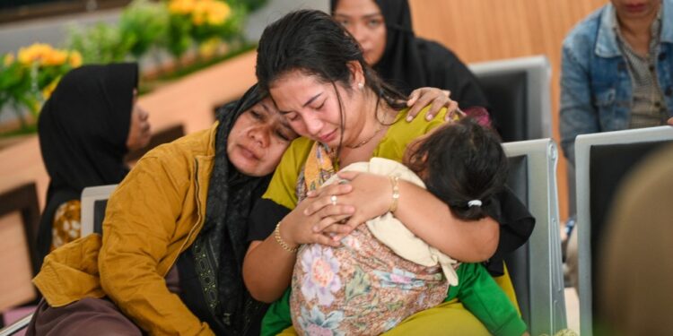 Los miembros de la familia afligidos esperan actualizaciones en un puerto.