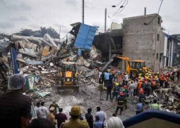 Los trabajadores de rescate buscan sobrevivientes en medio de los escombros de una fábrica química colapsada.