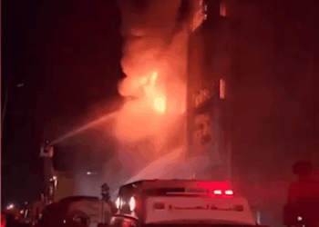 Los bomberos que luchan contra un gran incendio en la noche.