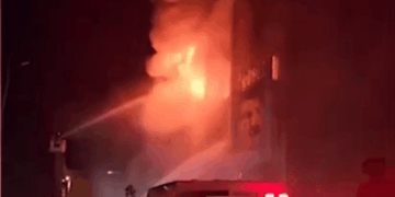 Los bomberos que luchan contra un gran incendio en la noche.