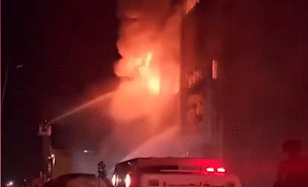 Los bomberos que luchan contra un gran incendio en la noche.
