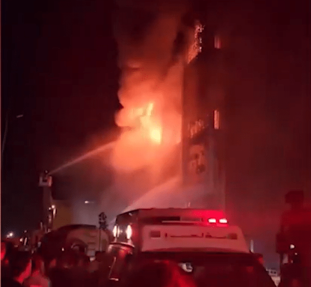 Los bomberos que luchan contra un gran incendio en la noche.