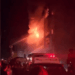Los bomberos que luchan contra un gran incendio en la noche.