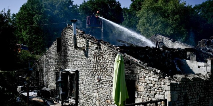 Los bomberos trabajan en el sitio de una casa de campo de vacaciones francés para adultos discapacitados, donde estalló un incendio dejando a una persona muerta y cuatro personas que todavía estaban desaparecidas en Montmoreau, suroeste de Francia, el 28 de julio de 2025. Según una fuente de Gendarmerie, 12 personas discapacitadas estaban dentro, ade de la pareja que dirigía la Gite. Se cree que el incendio fue causado por una falla en la instalación eléctrica, según la misma fuente. (Foto de Philippe Lopez / AFP) (Foto de Philippe Lopez / AFP a través de Getty Images)