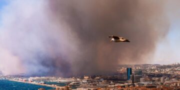 Humo de un incendio forestal masivo que oscurece una ciudad.