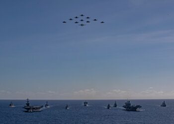 Vista aérea de múltiples buques de guerra navegando en formación.
