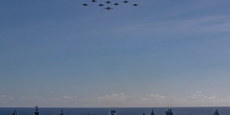 Vista aérea de múltiples buques de guerra navegando en formación.