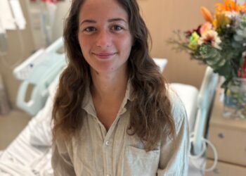 Mujer en la cama del hospital con oso de peluche.