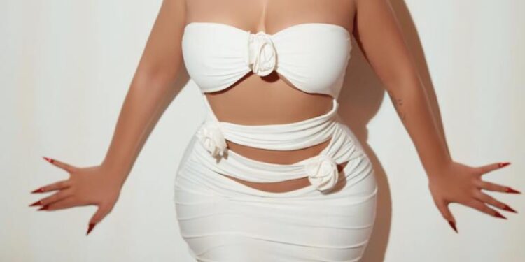 Mujer con vestido blanco contra una pared blanca.