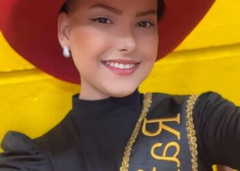 Retrato de Camila Trevisol, una reina de rodeo, con un sombrero de vaquero rojo y una hoja.