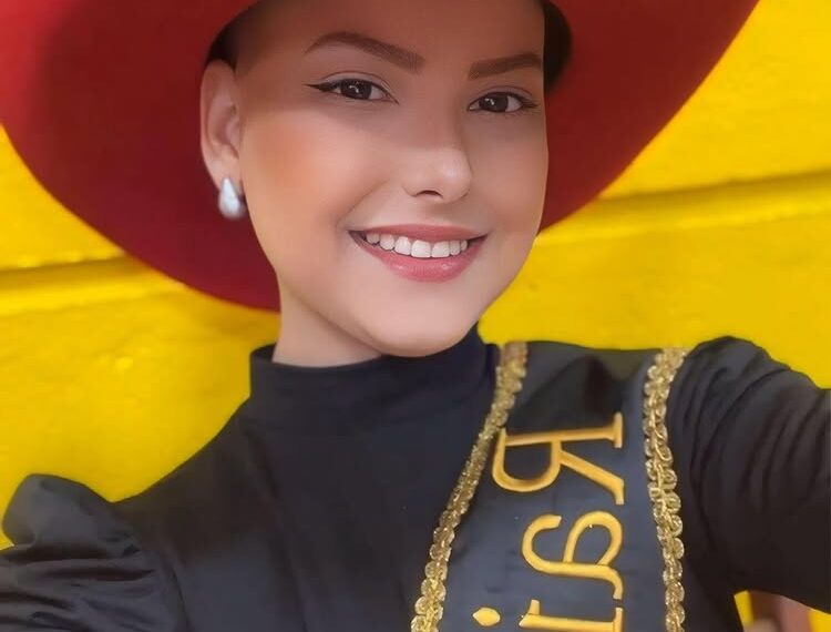 Retrato de Camila Trevisol, una reina de rodeo, con un sombrero de vaquero rojo y una hoja.