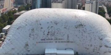Vista aérea de una gran cúpula inflable que cubre un sitio de construcción en una ciudad.