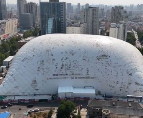 Vista aérea de una gran cúpula inflable que cubre un sitio de construcción en una ciudad.