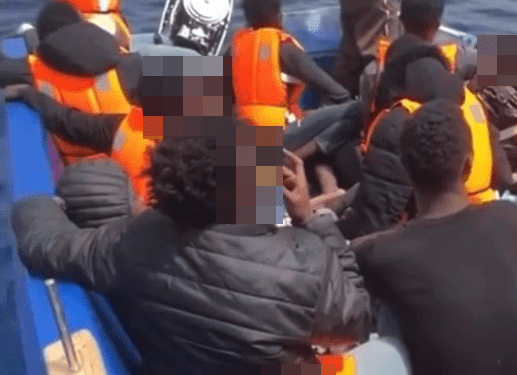 Migrantes en un bote en el mar.