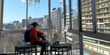 Persona filmando un hotel japonés abandonado con vistas a otros edificios.