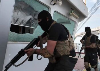 Hombres armados con equipo táctico negro a bordo de un barco.