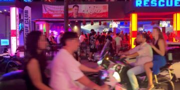 Gente en motocicletas afuera de un club nocturno.