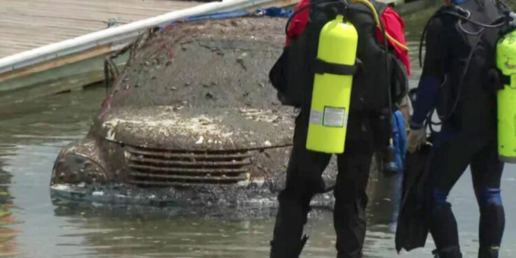 Auto cubierto de barro de agua; buzos cerca.
