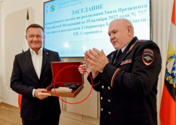 Una pistola en una caja de madera que se presenta a un hombre con traje.