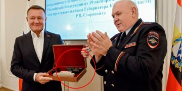 Una pistola en una caja de madera que se presenta a un hombre con traje.