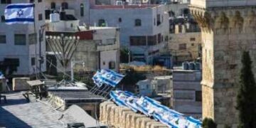 Las banderas israelíes se mueven en el viento en la mezquita de Ibrahimi después de que fue despojada de la autoridad del Ministerio Palestino de Dotaciones Religiosas y el Municipio de Hebrón, basado en una decisión israelí, en Hebrón, Cisjordania el 16 de julio de 2025.