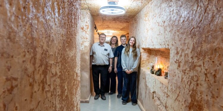 Familia posando en su casa subterránea en Coober Pedy, Australia.