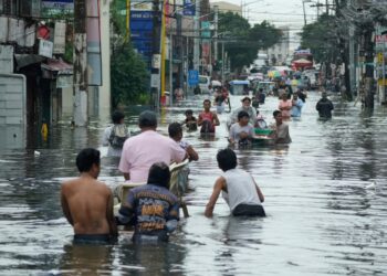Los residentes pasan por una calle inundada en la ciudad de Malabon, Filipinas.