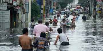 Los residentes pasan por una calle inundada en la ciudad de Malabon, Filipinas.