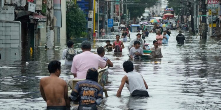 Los residentes pasan por una calle inundada en la ciudad de Malabon, Filipinas.