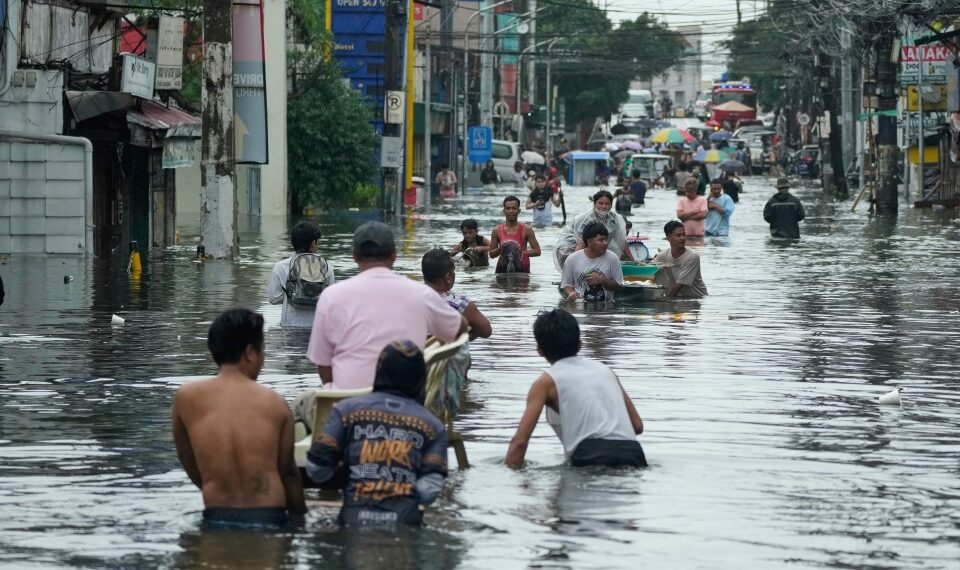 Los residentes pasan por una calle inundada en la ciudad de Malabon, Filipinas.