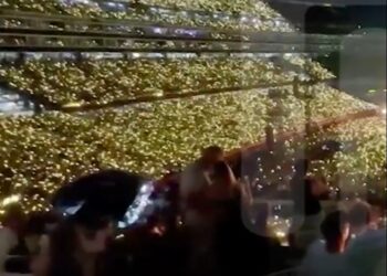 Multitud del estadio sosteniendo luces.