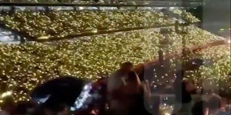 Multitud del estadio sosteniendo luces.