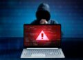 Ilustración de una computadora portátil que muestra código de error con una figura con capucha en el fondo.
