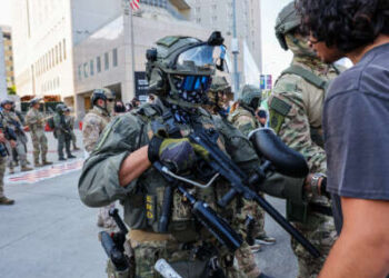 Un ser humano confronta a un agente uniformado y armado de los Estados Unidos