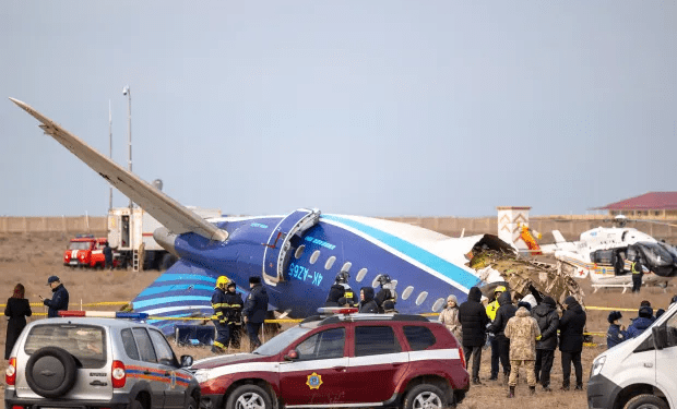 Accidente aéreo en un aeropuerto con personal de emergencia y espectadores.