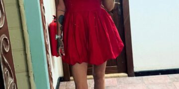 Mujer con vestido rojo tomando una selfie.