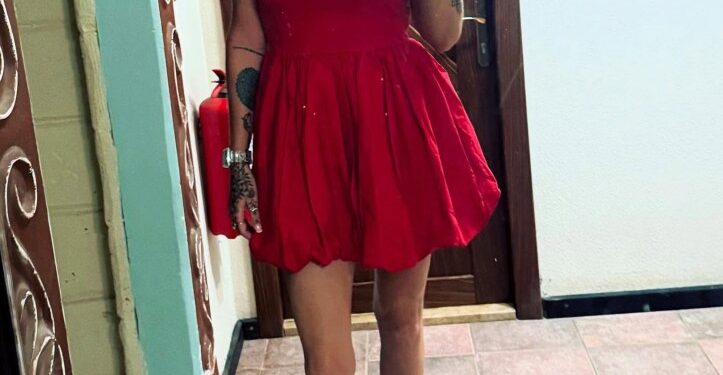 Mujer con vestido rojo tomando una selfie.